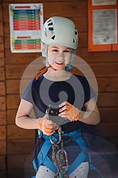 Portrait of 8 years old girl in forest adventure park. Outdoor playground with rope way.