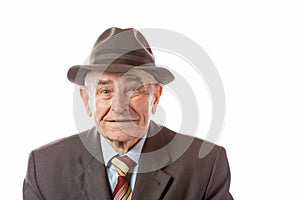 Portrait of 90 year old senior man in retro hat looking at camera isolated on white background