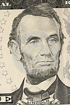 A portrait of Abraham Lincoln on the bill in five US dollar