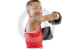 Portrait of active boy, beginner boxer in sports gloves and red uniform isolated on white background. Concept of sport