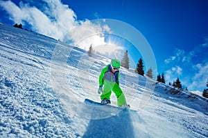 Portrait of an active boy move fast on snowboard