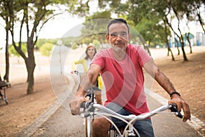 Portrait of active mature man riding bike in park
