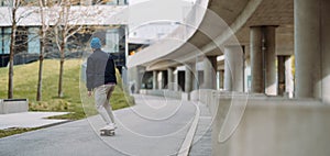 Portrait of active skater boy balancing on skateboard on urban background. Banner copy space. Focused skateboarder