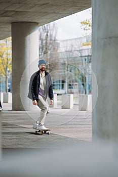 Portrait of active skater boy balancing on skateboard on urban background Focused skateboarder moving on skate board