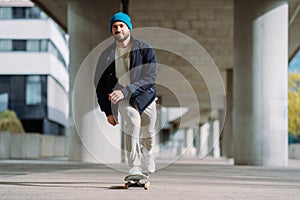 Portrait of active skater boy balancing on skateboard on urban background Focused skateboarder moving on skate board