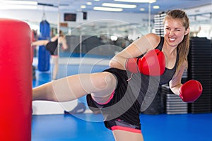 Portrait of active woman boxing with punching bag