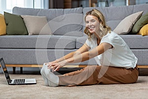 Portrait of active woman at home doing fitness and exercise and yoga, mature housewife looking at camera and smiling