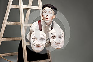 Portrait of an actor with facial masks on the grey background