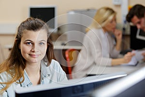 Portrait adolescent female student sat at computer