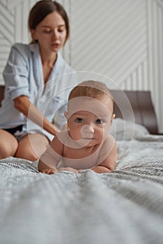 Portrait of adorable baby in bed lying on tummy