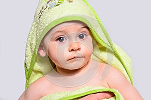 Portrait of an adorable baby boy wearing a towel after bath.