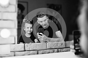 Portrait of adorable beautiful caucasian siblings brother and sister doing selfie in the make up mirror.