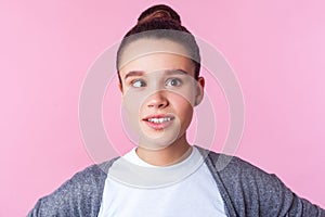 Portrait of adorable funny brunette teen girl fooling around with crossed eyes, having fun. isolated on pink background