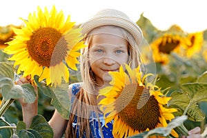 Portrait of adorable girl with sunflower on field