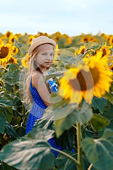 Portrait of adorable girl with sunflower on field