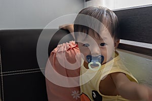 Adorable and happy Chinese 1 year old baby boy child playing on bed