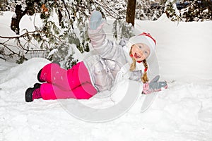 Portrait of adorable happy little girl grinning happily at the camera on a sunny winter`s day