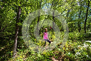 Portrait of adorable hiking little girl on spring day in forest