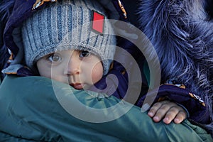 Portrait of adorable infant boy in warm winter clothes