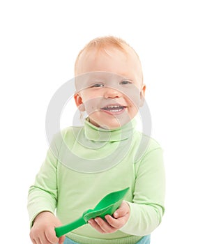 Portrait of adorable joyful boy with toy shovel