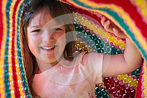 Portrait of adorable kid playing under blanket. Lifetime moments and happy childhood concept