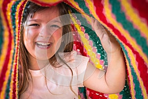 Portrait of adorable kid playing under blanket. Lifetime moments and happy childhood concept