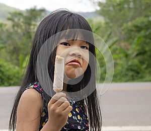 Portrait of  adorable little Asian girl with long black hair dress casual holding ice cream. Happy and holiday concept