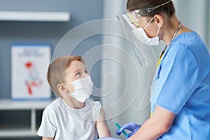 Portrait of adorable little boy being vaccinate at doctor`s office