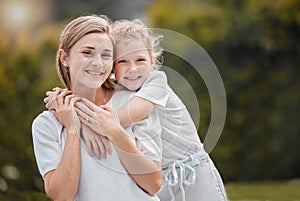 Portrait of an adorable little girl hugging her mother from behind while bonding with her in the garden at home