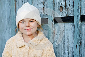 Portrait of adorable little girl outdoors on cold winter day. Cute preschool child in warm clothes, with knitted hat and