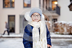 Portrait of adorable little girl outdoors on cold winter day. Cute preschool child in warm clothes, with knitted hat and