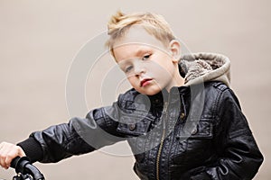 Portrait of adorable little urban boy wearing black leather jack