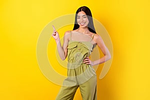 Portrait of adorable lovely person indicate finger empty space blank isolated on yellow color background
