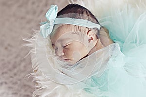 Portrait of adorable newborn baby with floral head band sleeping