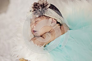 Portrait of adorable newborn baby with floral head band sleeping