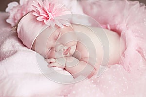 Portrait of adorable sleeping baby girl over pink, infant child.