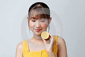 Portrait of adorable smiling girl with lemon, over white