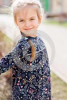 Portrait of adorable smiling little girl child in dress outdoor in summer day