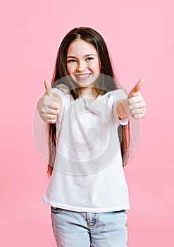 Portrait of adorable smiling little girl child in jeans and white t-shirt with two fingers up isolated