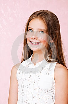 Portrait of adorable smiling little girl child schoolgirl teenager in dress with long hair