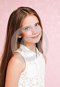 Portrait of adorable smiling little girl child schoolgirl teenager in dress with long hair