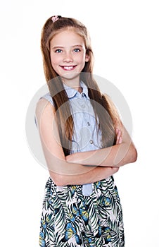 Portrait of adorable smiling little girl child schoolgirl teenager in dress with long hair standing isolated