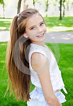 Portrait of adorable smiling little girl child schoolgirl teenager outdoors