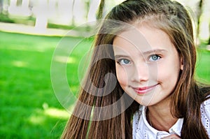 Portrait of adorable smiling little girl child schoolgirl teenager outdoors