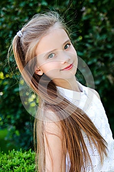 Portrait of adorable smiling little girl child schoolgirl teenager outdoors