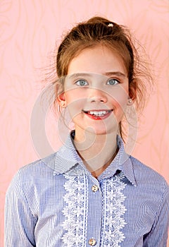 Portrait of adorable smiling little girl schoolgirl child isolated