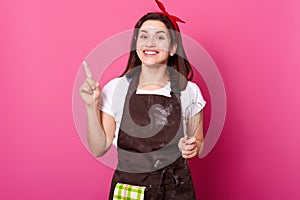 Portrait of adorable young girl holding her finger up. Funny creative female produces new ideas of cooking with enthusiasm. photo
