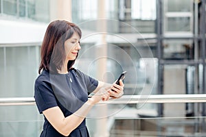 Adult businesswomen in suit using smartphone