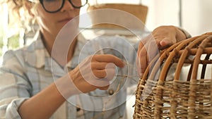 Portrait of adult caucasian woman doing hobby leisure diy activity at home making a lamp with recycled cords. Second hand use of