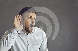 Portrait of adult man eavesdrop with hearing gesture listen shock news